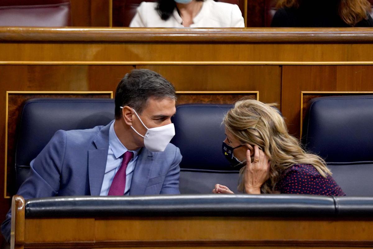 Pedro Sánchez y Yolanda Díaz conversan en sus escaños del Congreso. 