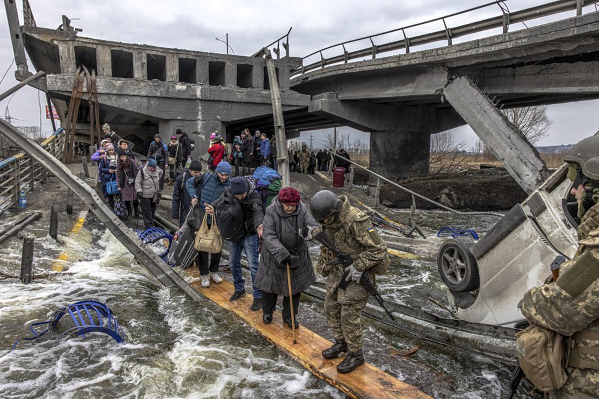 Ucranianos atraviesan las ruinas del puente de Irpin para huir de la guerra, el 7 de marzo de 2022. 