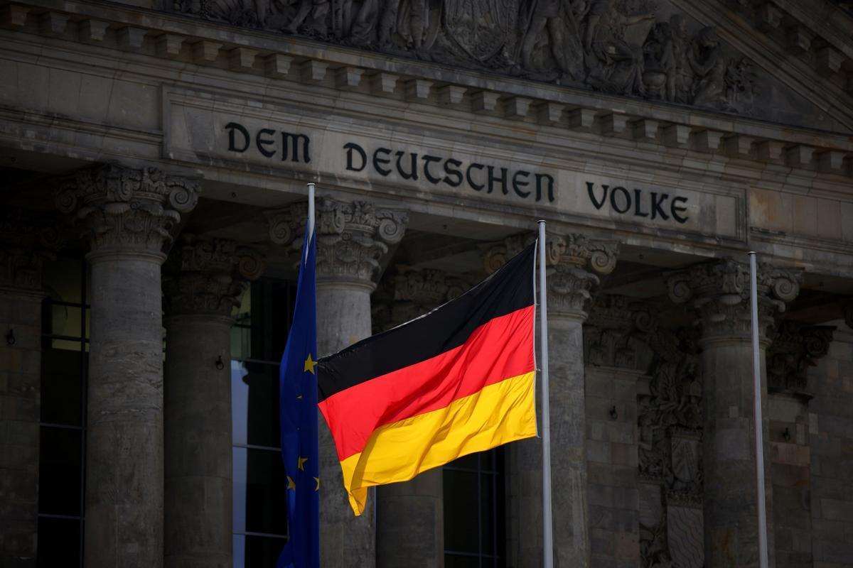 La bandera alemana ondea frente al edificio del Reichstag.