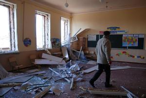 Un hombre camina entre los escombros de un colegio bombardeado por las tropas rusas.
