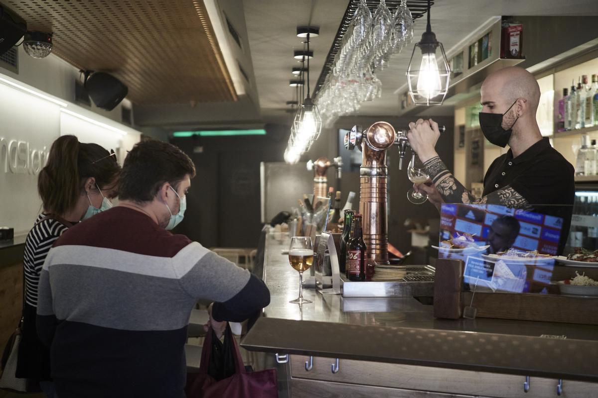 Un camarero atiende a unos clientes en un bar de Pamplona.