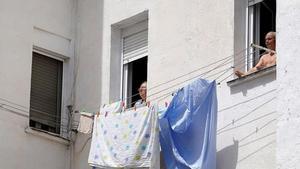 Dos personas mayores toman el sol en la ventana vivienda en Madrid. José Luis Roca