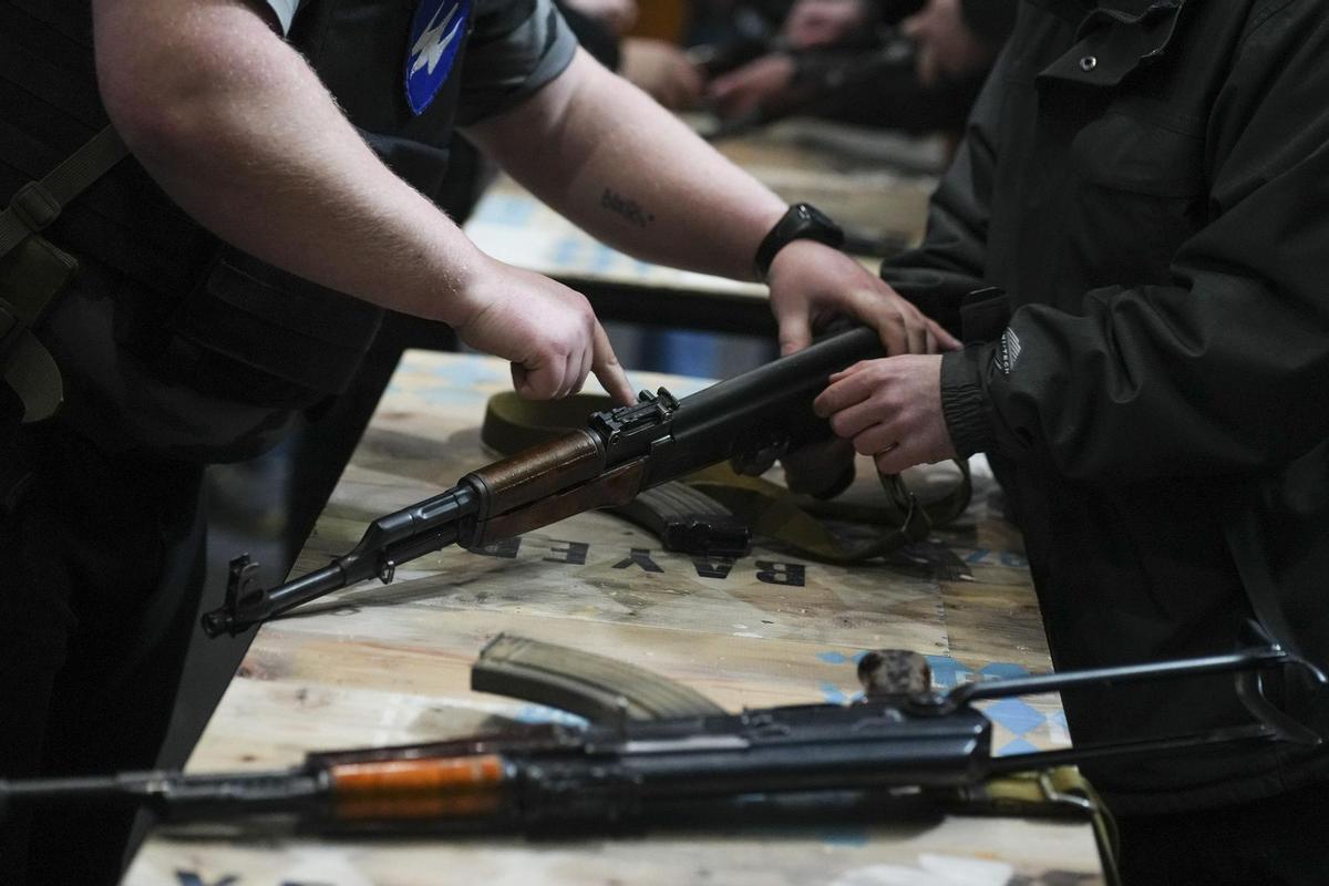 Instructores de armamento enseñan a manejar armas de guerra a civiles ucranianos.