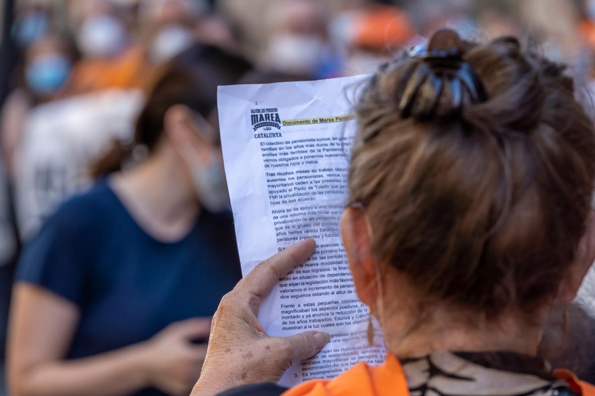 Una manifestante lee un manifiesto en una protesta para salvar las pensiones en Barceloba.
