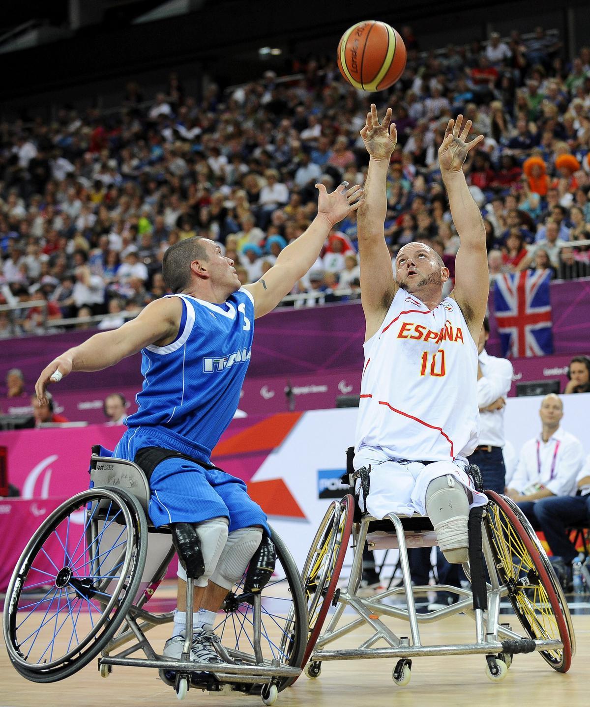 Dos deportistas practican baloncesto en silla de ruedas.
