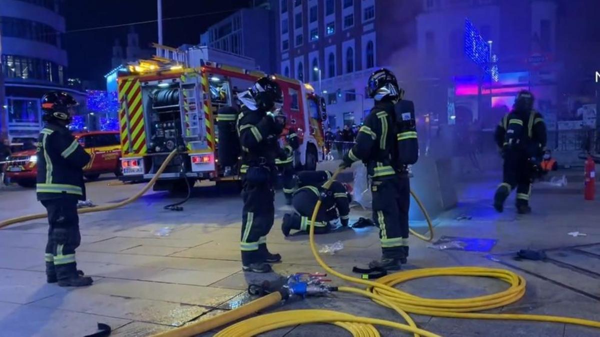 Bomberos trabajan en las labores para extinguir un incendio en Callao, Madrid, el 26 de diciembre de 2022