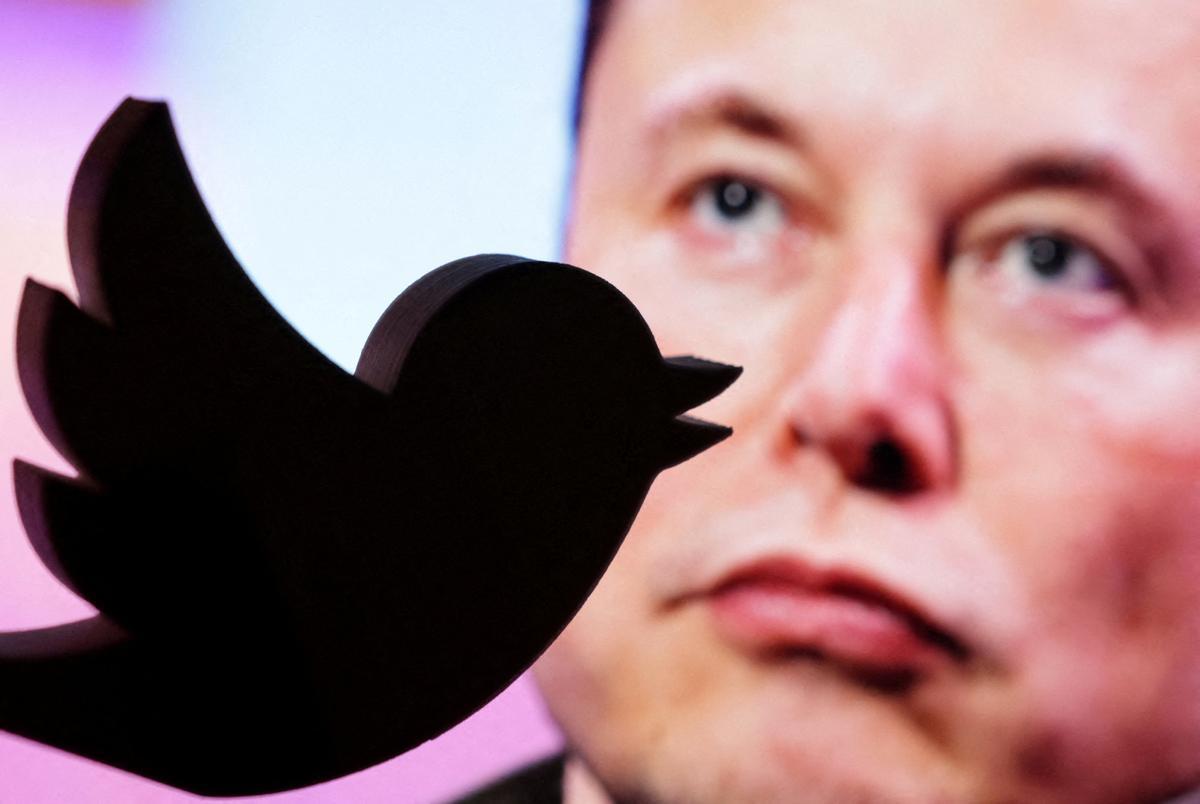 Elon Musk, tras el logotipo de Twitter.