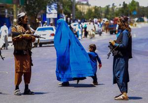 Una mujer camina junto a un niño en Afganistán.