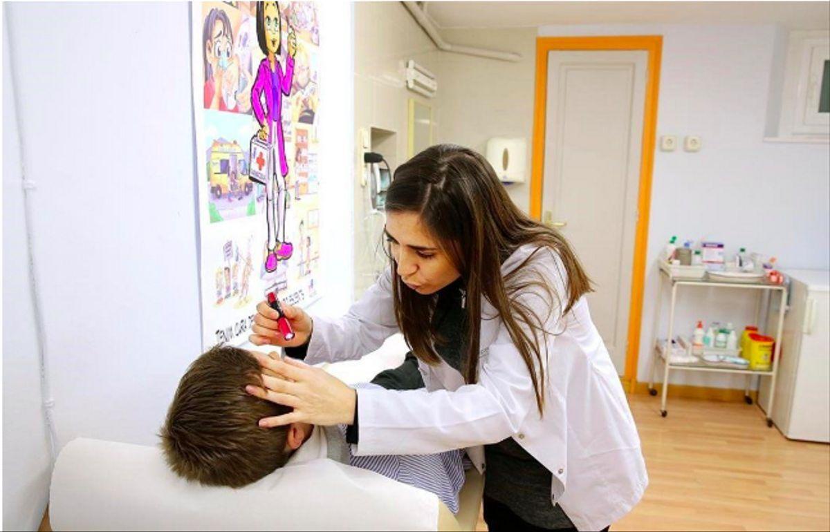 Una enfermera atiende a un alumno en un colegio de Barcelona.