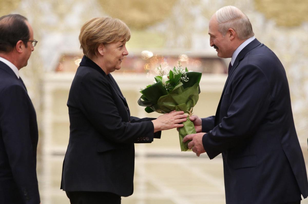 Imagen fechada en 2015 en la que la canciller alemana, Angela Merkel recibía un ramo de flores de manos del presidente bielorruso, Alexánder Lukashenko, a su llegada a la cumbre de mandatarios cuatripartita para la paz en Ucrania, celebrada en Minsk. EFE/TATYANA ZENKOVICH