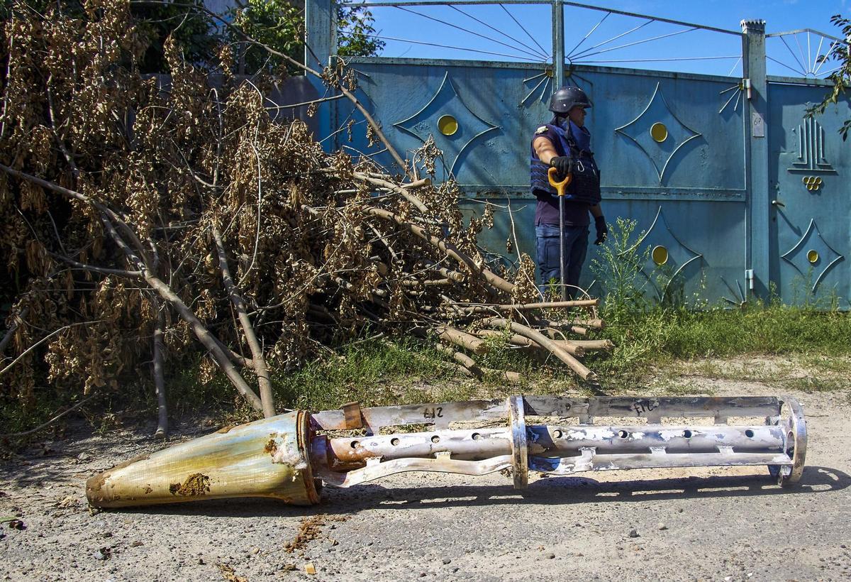 Kharkiv (Ukraine), 22/08/2022.- Policemen inspect debris of a rocket at the site of a shelling near Kharkiv, Ukraine, 22 August 2022 . At least two civilians were injured during the attack, the Emergency service said. Kharkiv and surrounding areas have been the target of heavy shelling since February 2022, when Russian troops entered Ukraine starting a conflict that has provoked destruction and a humanitarian crisis. (Atentado, Rusia, Ucrania) EFE/EPA/SERGEY KOZLOV