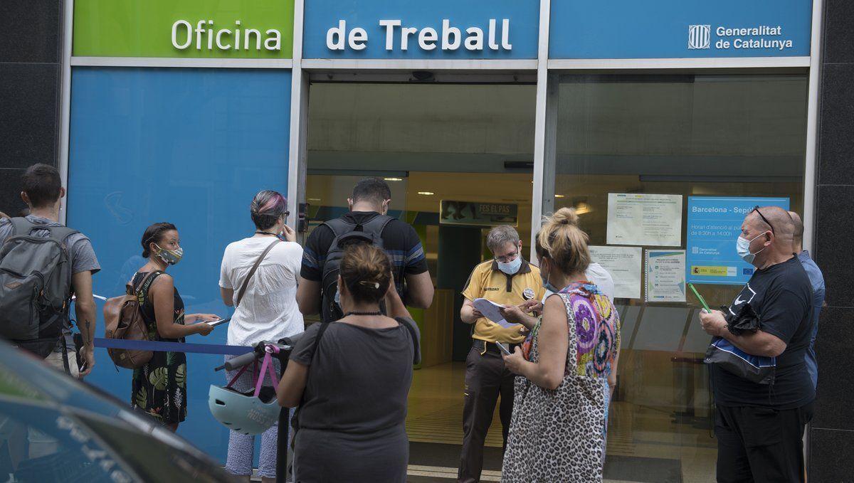 Varias personas esperan en la puerta de una oficina pública de empleo en Cataluña.