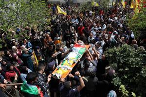 Varios palestinos portan el cuerpo de un joven muerto en un enfrentamiento con fuerzas israelíes.