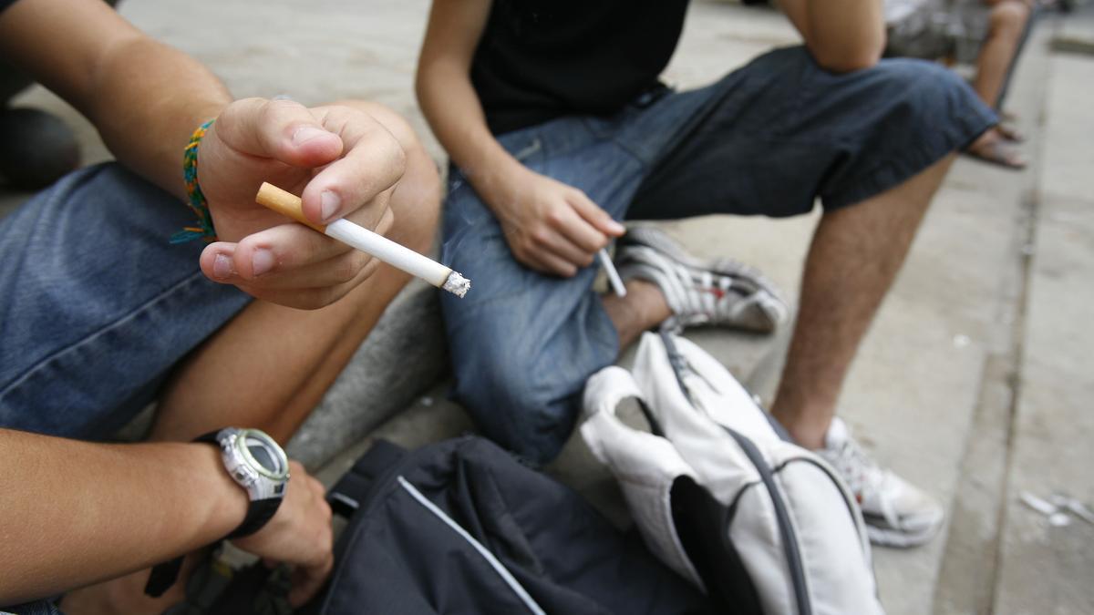 Jóvenes fumando un cigarrillo.
