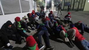 Un grupo de migrantes subsaharianos realizan una sentada en el CETI de Ceuta