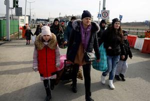 Refugiados ucranianos cruzan la frontera entre su país y Polonia por la población de Medyka.