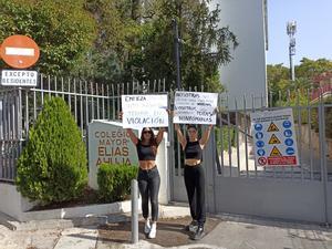 Dos estudiantes de la Complutense realizan una protesta esta mañana frente al Colegio Mayor. 