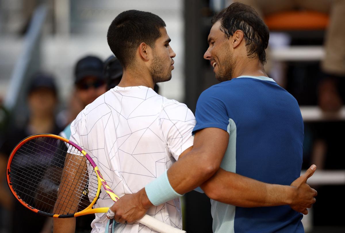 Los tenistas españoles Carlitos Alcaraz y Rafa Nadal se saludan tras su partido en el Open de Madrid.