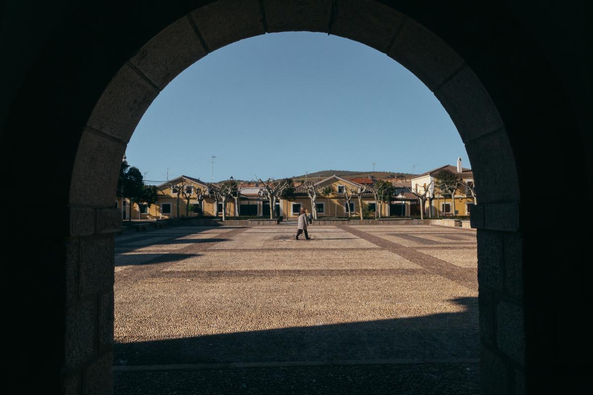 Una vecina pasa por la Plaza del Ayuntamiento de Alcaudete de la Jara, en Toledo. 