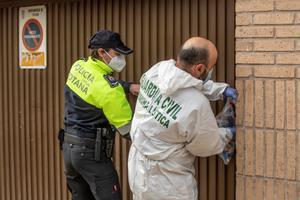 Un agente de la unidad criminalística de la Guardia Civil y uno de la Policía Local de Totona (Murcia) cierran el garaje de la calle de la Rambla número 7 donde este miércoles ha aparecido, en el interior de un trastero, el cadáver de la joven Claudia Abigaíl, de 17 años, que llevaba 24 horas desaparecida. 