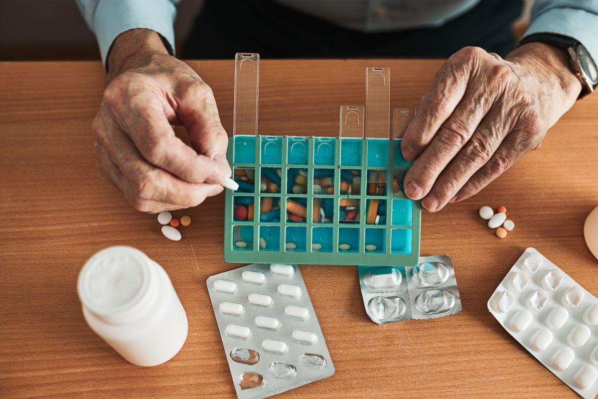 Un hombre organiza sus medicamentos. 