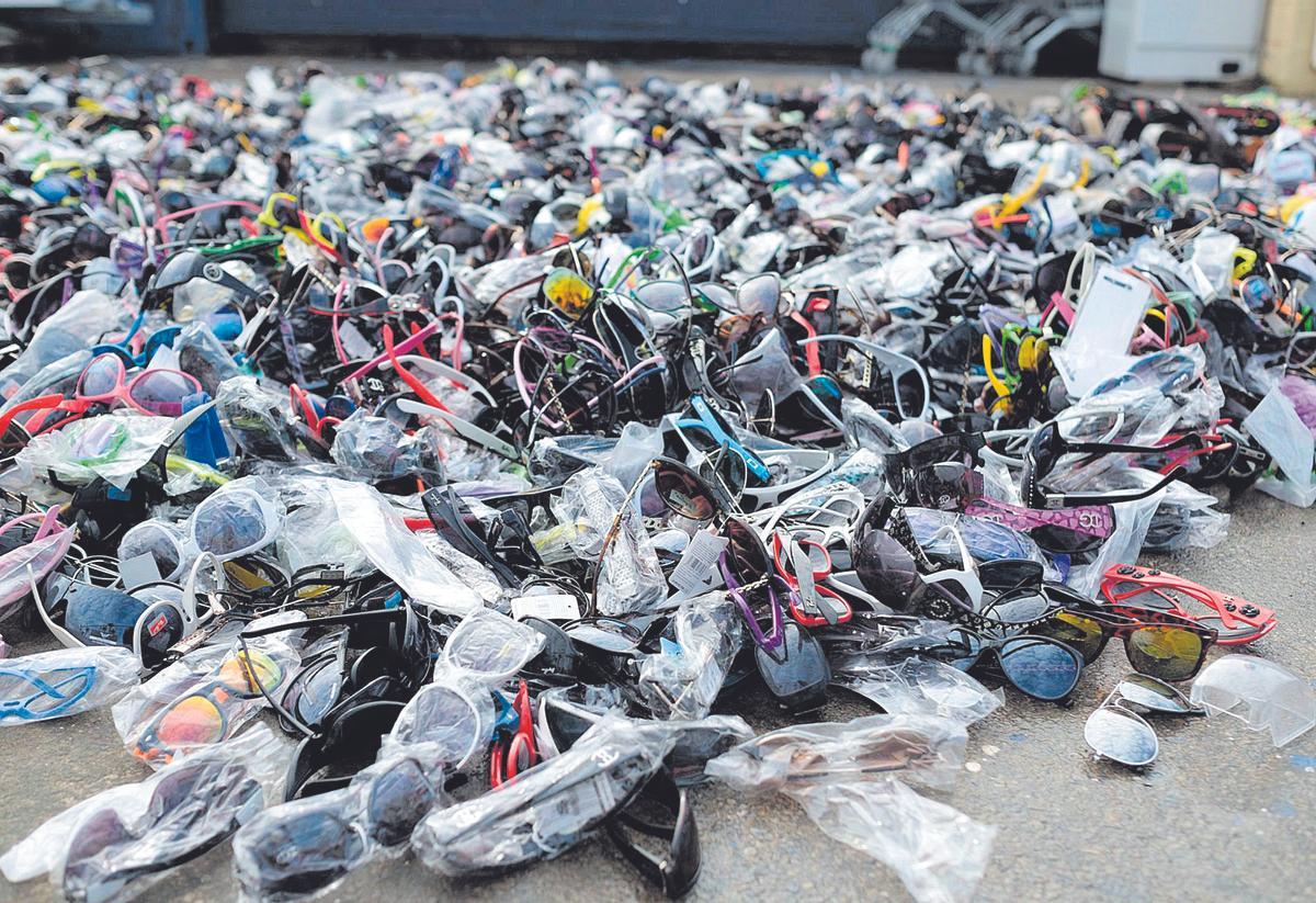 Cientos de gafas falsificadas apiladas en el suelo de un almacén