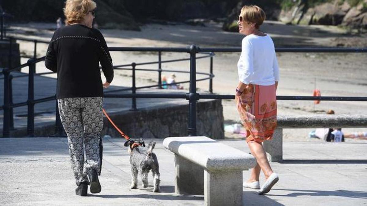 Dos mujeres paseando a un perro en Oleiros (A Coruña).