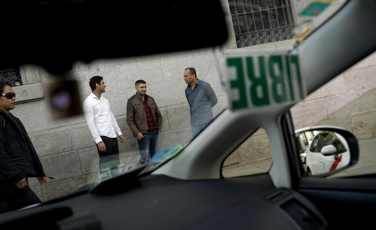 Farmad Hasan, Muhammad Bilal y Muhammad Adeel Yagoob en la parada de taxis de Ópera, en Madrid.