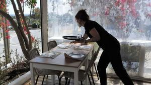 Una camarera prepara una mesa en una terraza de un restaurante de Sant Francesc.
