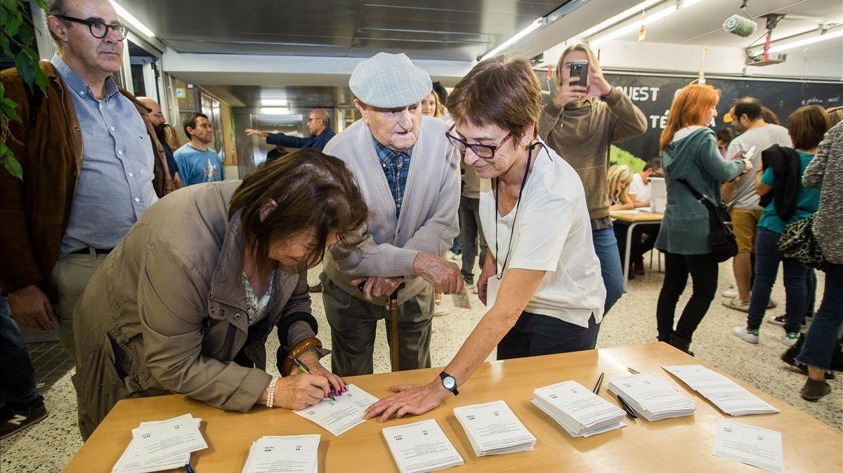 Varias personas votan durante el referéndum independentista del 1 de octubre de 2017.