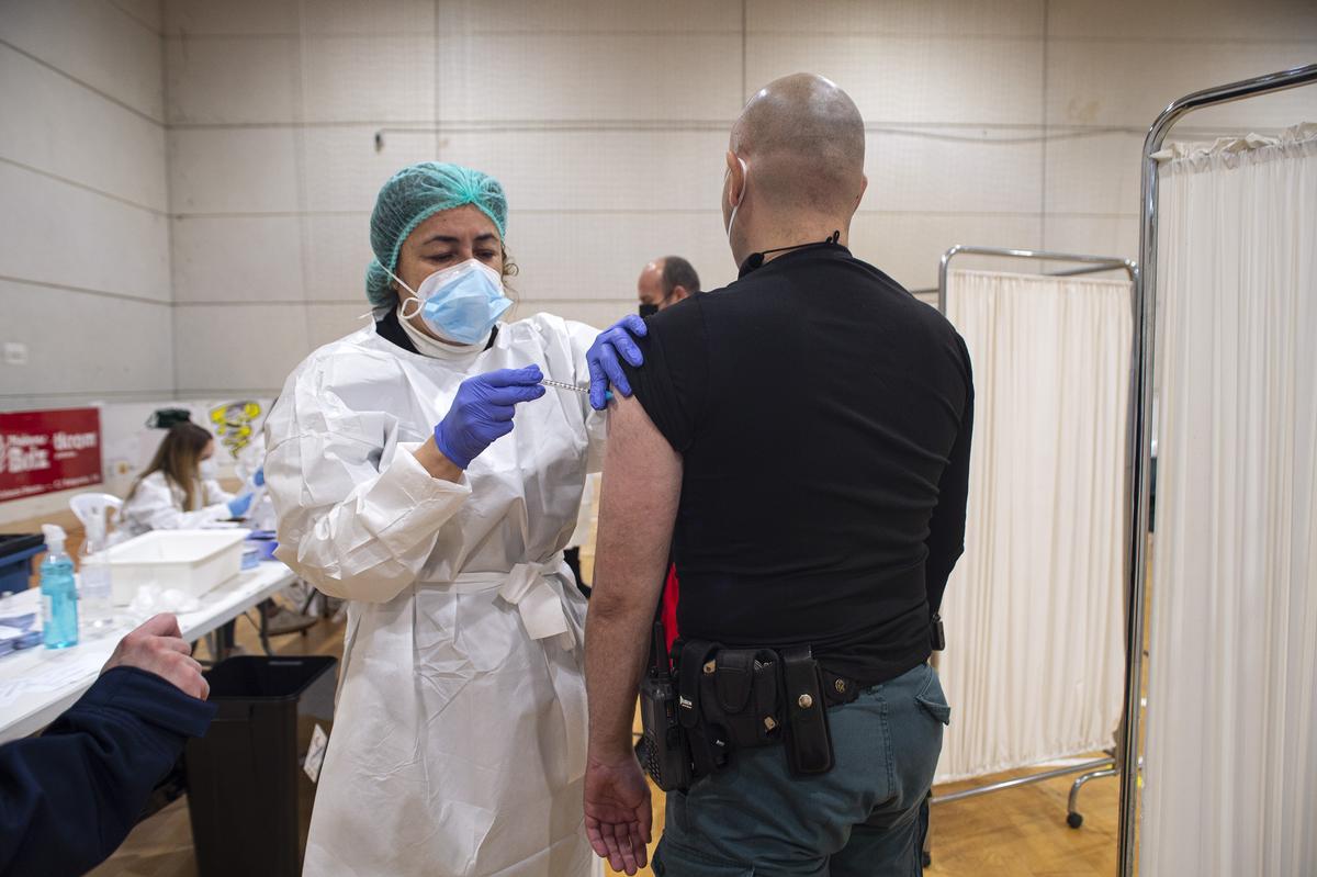 Una sanitaria administra la vacuna frente al covid a un guardia civil. Una sanitaria administra la vacuna frente al covid a un guardia civil.