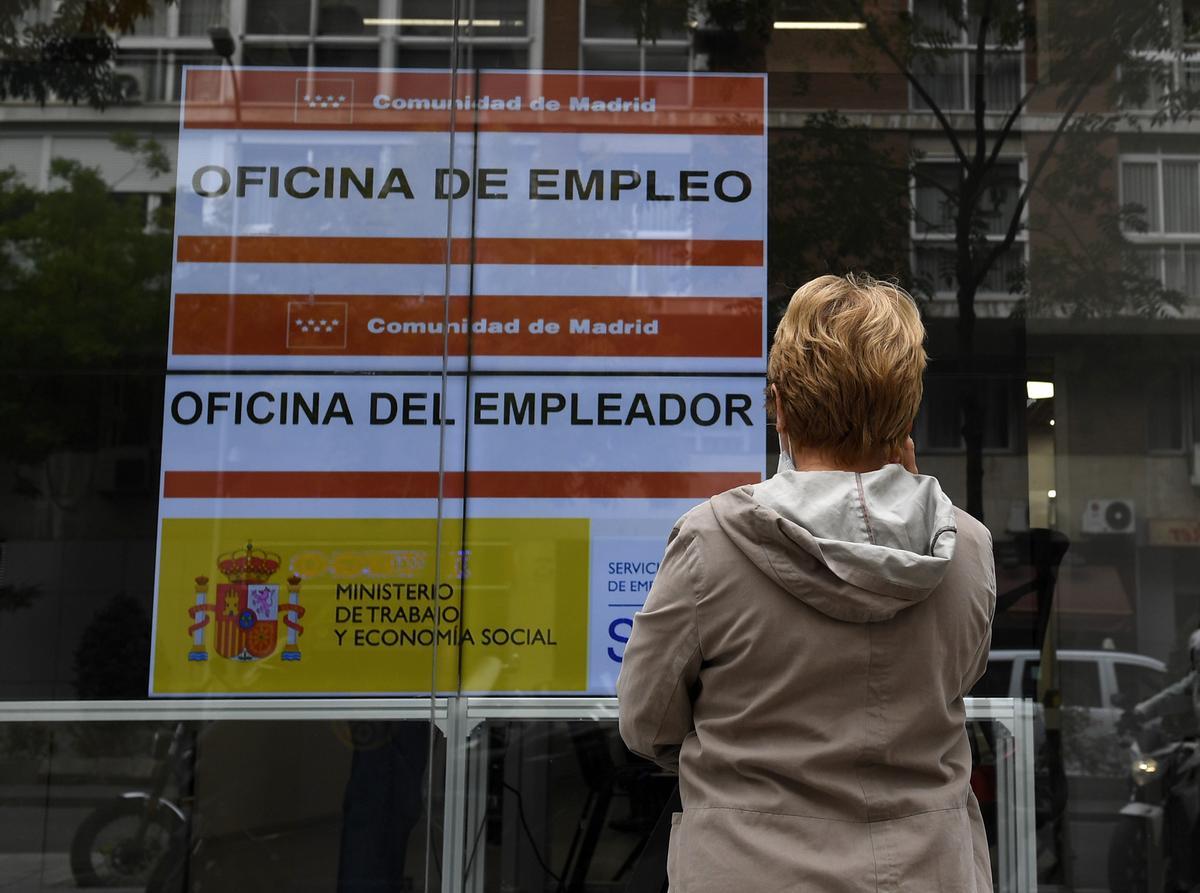 Una mujer observa los carteles de una oficina de empleo.