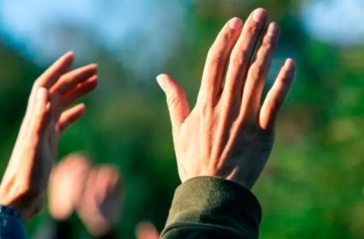 Un hombre alza la mano en una reunión de una secta