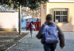 Dos niños entrando en un colegio.