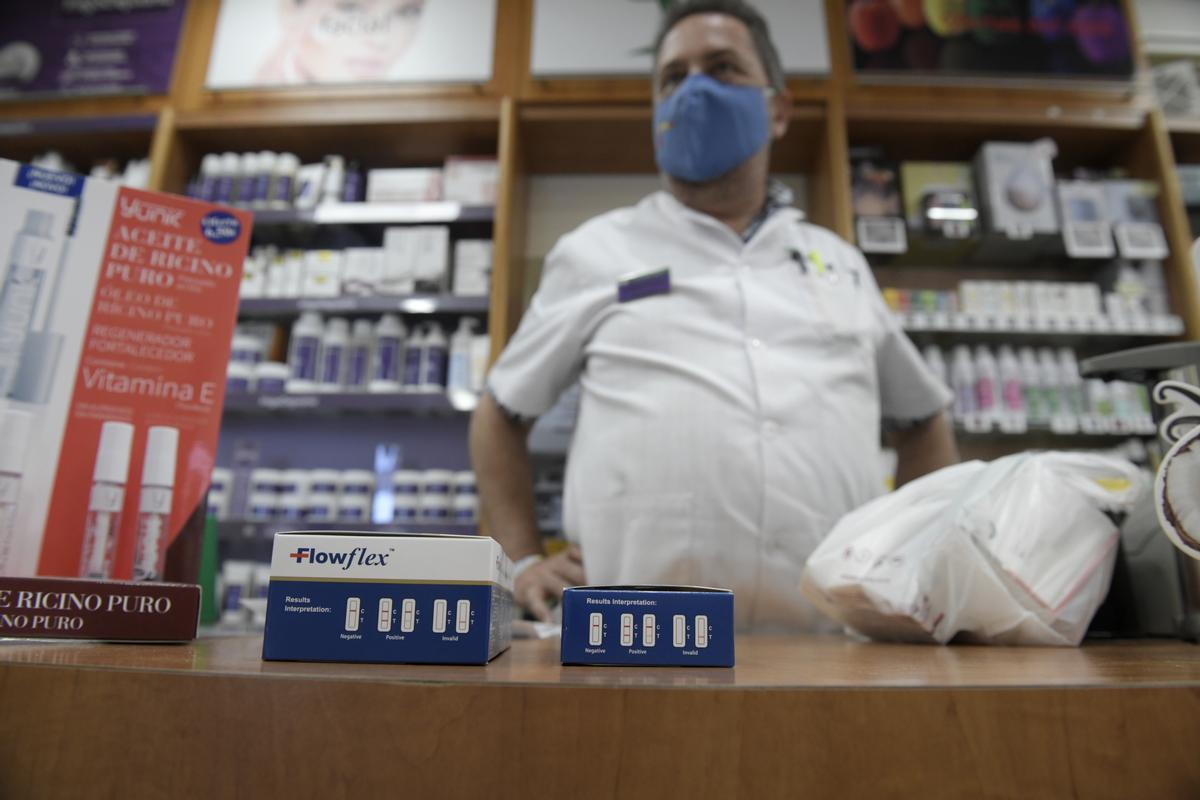 Un farmacéutico muestra un test de antígeno en un establecimiento de Madrid.