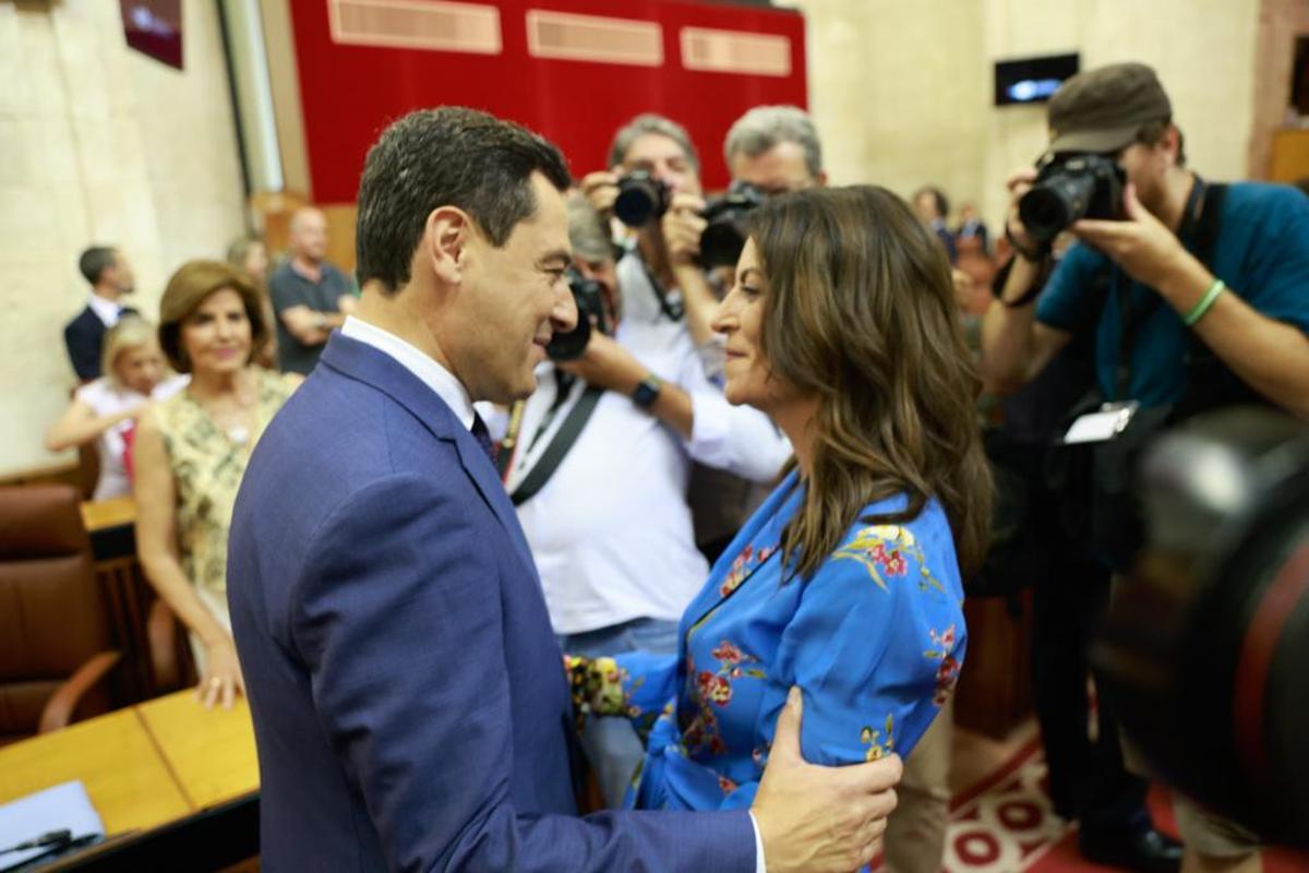 El presidente andaluz, Juan Manuel Moreno, saluda a Macarena Olona, portavoz de Vox, tras jurar su cargo como diputada.