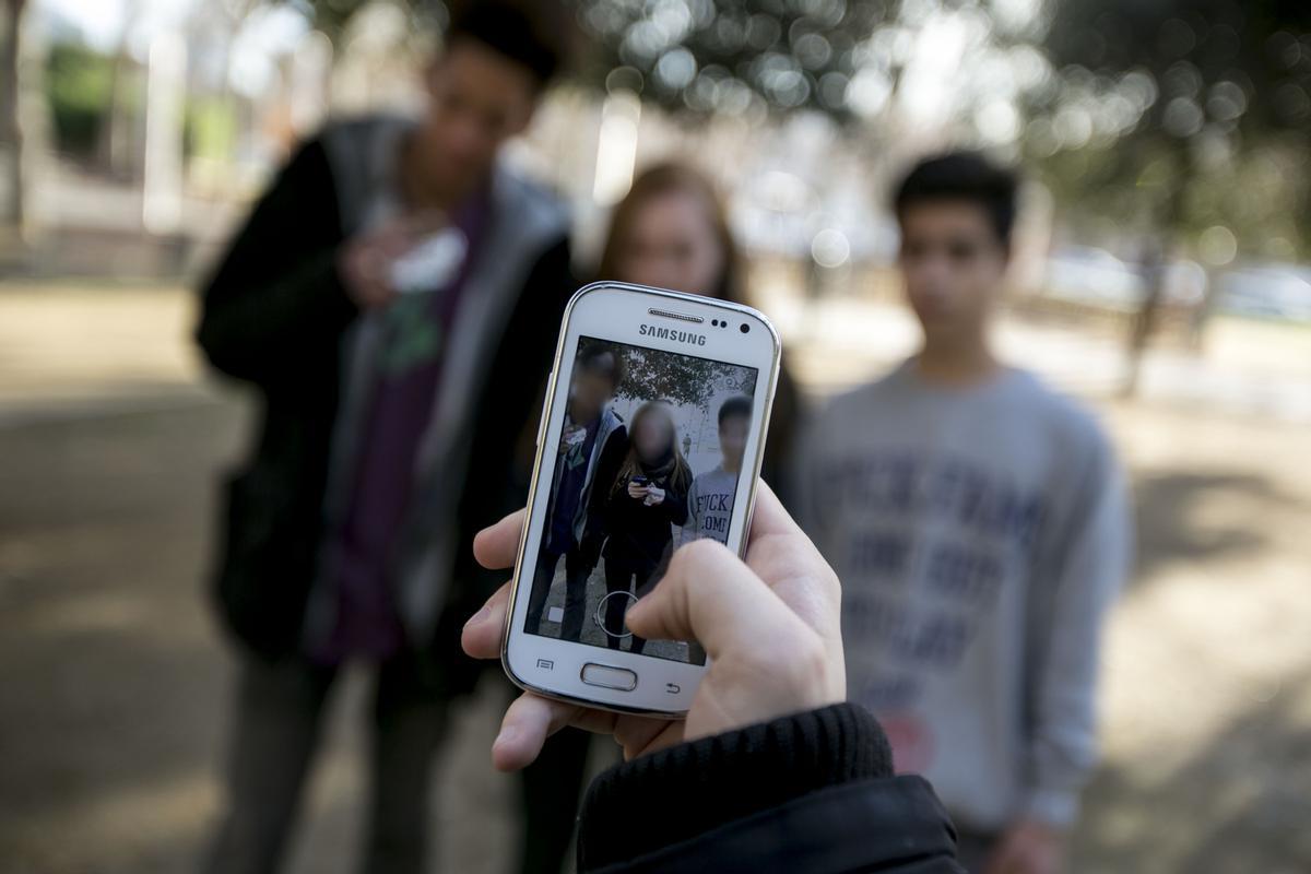 Un grupo de adolescentes con su móvil. 