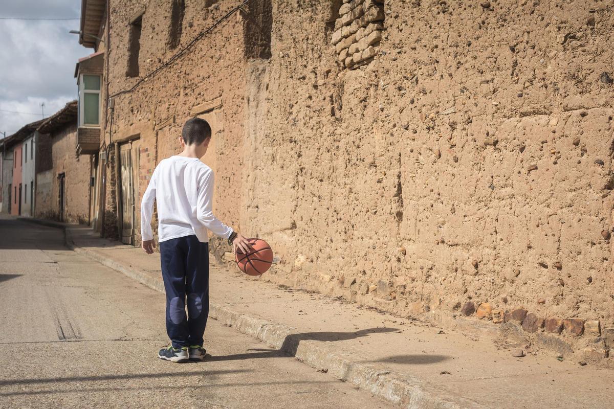 Un niño juega en las calles de un pueblo.