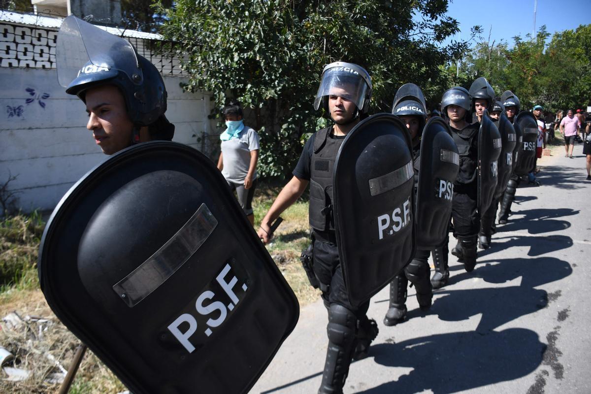 Agentes de policía llegan al lugar en el que un grupo de vecinos han destruido la casa de un supuesto traficante de drogas en Rosario, Argentina, en las protestas por la muerte el sábado de un niño en la calle durante un tiroteo.