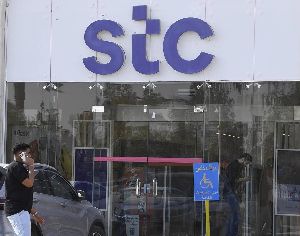 Un hombre habla por teléfono delante de un establecimiento de Saudi Telecommunication Company (STC) en Riad.