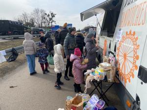 Refugiados aguardan su turno en un puesto de comida en Dorohusk (Polonia).