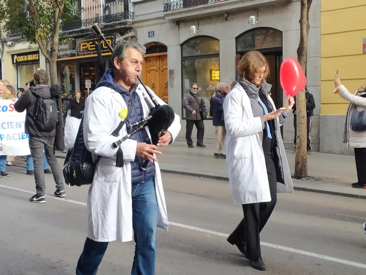Un médico toca la gaita durante una marcha en Madrid.