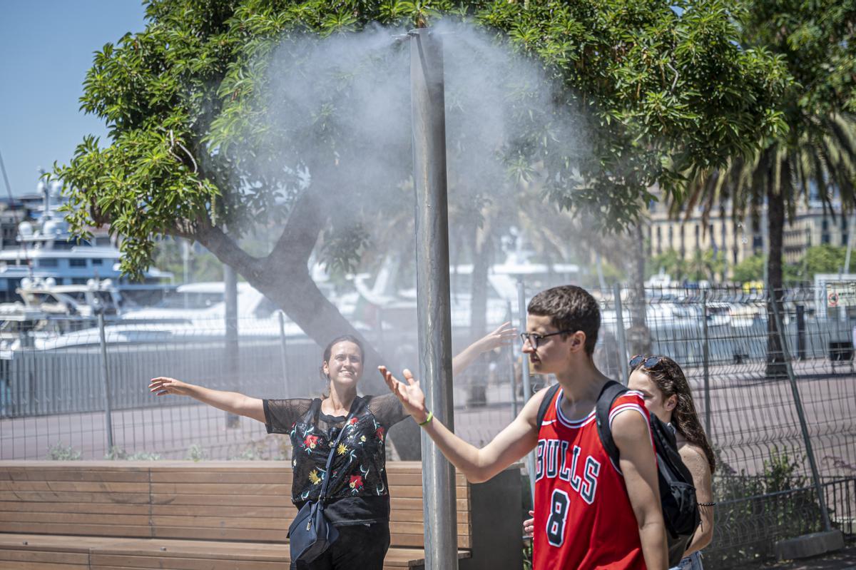 Varias personas se refrescan en una fuente. EPC Varias personas se refrescan en una fuente. EPC