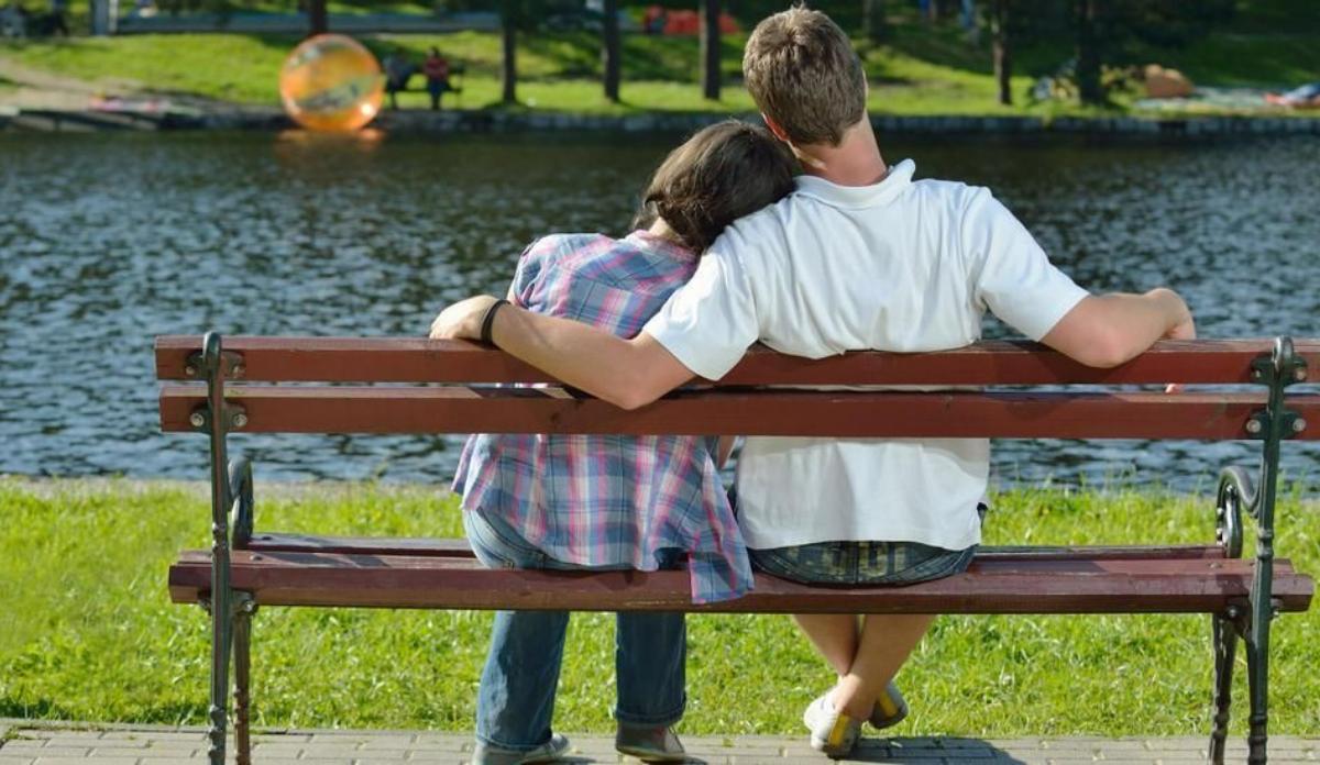 Una pareja, en el banco de un parque.