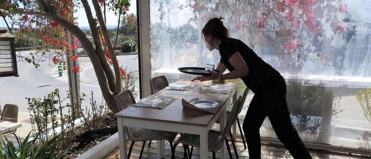 Una camarera prepara una mesa en una terraza de un restaurante de Sant Francesc. Una camarera prepara una mesa en una terraza de un restaurante de Sant Francesc.