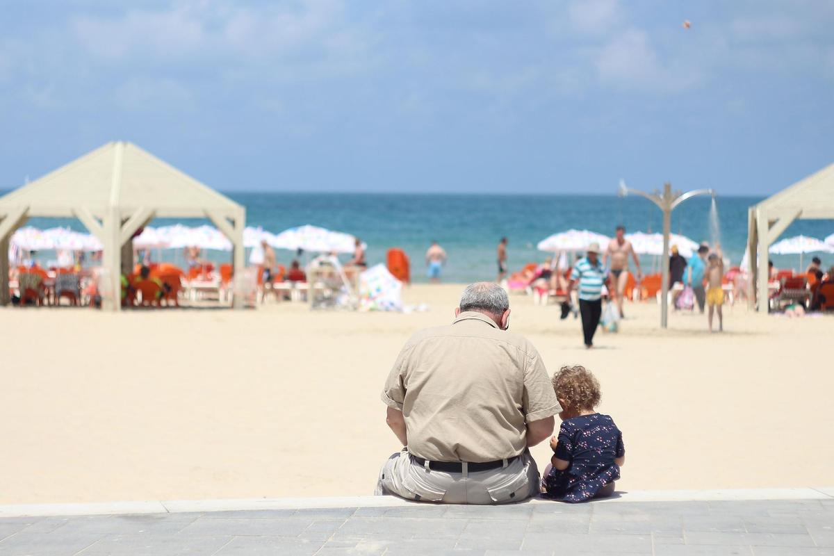 Un abuelo con su nieta en la playa. 