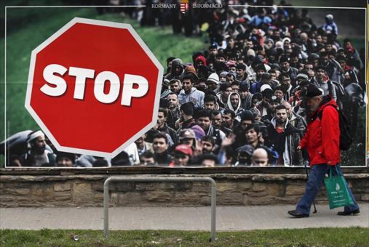 Un hombre, junto a un cartel contra la inmigración, ayer en Budapest.