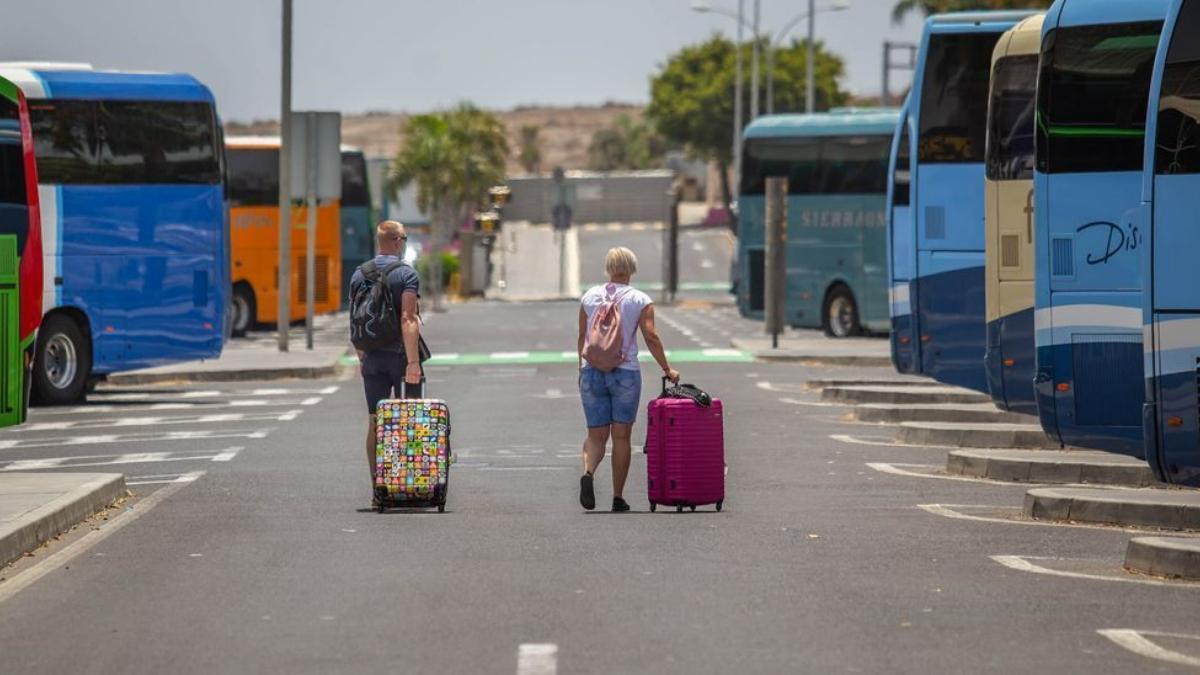 Una pareja de turistas extranjeros arrastra sus maletas a la salida del aeropuerto Tenerife Sur.