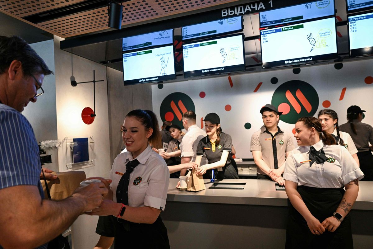Un empleado da a un cliente su comida en un restaurante de la versión rusa del antiguo McDonald’s este 12 de junio de 2022. Un empleado da a un cliente su comida en un restaurante de la versión rusa del antiguo McDonald’s este 12 de junio de 2022.