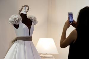 Una mujer toma una foto de un vestido de boda